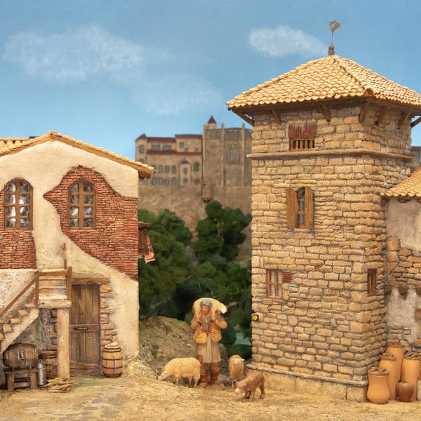 Pastor entre edificios con las murallas de Pamplona al fondo